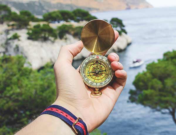 A hand holding a compass